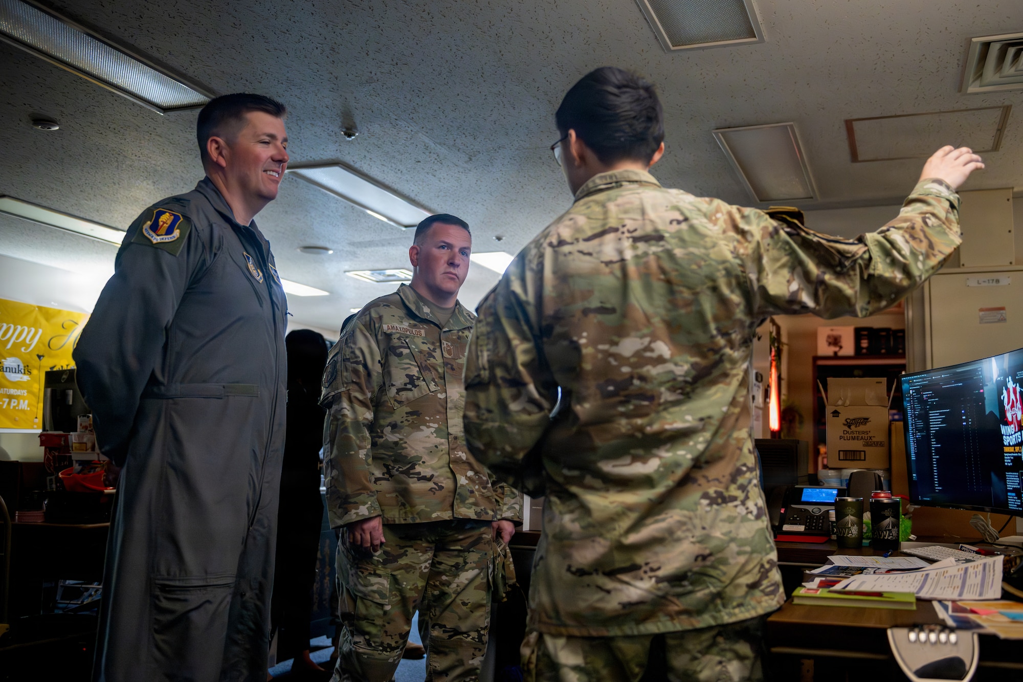 U.S. Air Force Senior Airman Edwin Jiminez Reyes, 35th Force Support Squadron marketing and publicity communications specialist, right, explains ongoing projects for the marketing office to Col. Matthew Hoyt, 35th Fighter Wing deputy commander, left, and Chief Master Sgt. Jason Amaxopulos, 35th FW command chief, during a Wild Weasel Walk-Through.