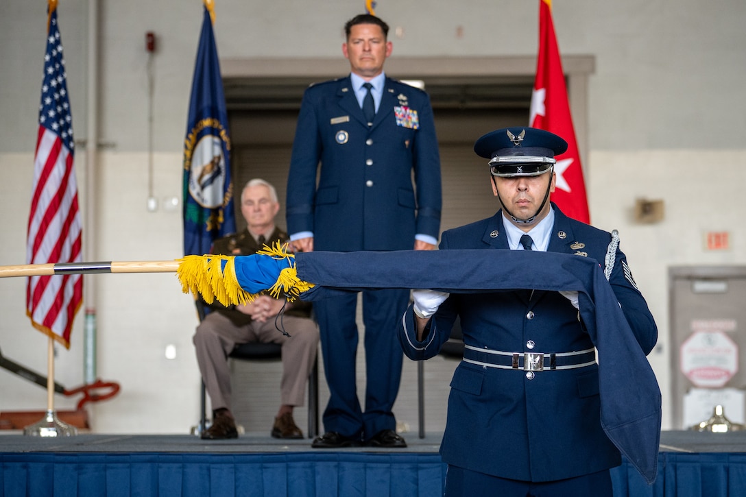 Newly promoted Brig. Gen. Ash Groves looks on as the 123rd Airlift Wing Honor Guard unfurls a brigadier general’s flag during his promotion ceremony at the Kentucky Air National Guard Base in Louisville, Ky., June 7, 2026. Groves, who previously served as director of the Air staff at Joint Force Headquarters-Kentucky, is now chief of the Air staff at JFHQ-KY. (U.S. Air National Guard photo by Senior Airman Annaliese Billings)