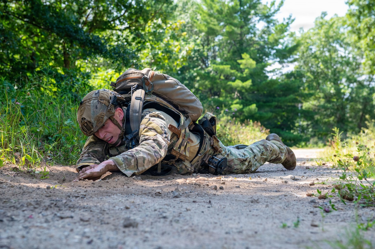 A U.S. Air Force explosive ordnance disposal technician inspects an explosive during a simulated dismounted route clearance during the fourteenth annual Audacious Warrior Exercise, at Volk Field Air National Guard Base, Camp Douglas, Wisconsin, July 20, 2026. Audacious Warrior is an annual exercise designed to convene Explosive Ordnance Disposal technicians from various backgrounds to train on the latest EOD scenarios, enhance operational readiness, and exchange knowledge and techniques. (U.S. Air National Guard photo by Senior Airman Jessica Duch)