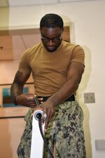 Navy Medicine Readiness and Training Command Pensacola Sailor, Hospital Corpsman 3rd Class, Biomedical Equipment Technician, Samuel Toe, assigned to Naval Hospital Pensacola, feeds wiring through a dental X-Ray unit arm during an X-ray installation, Naval Branch Health Clinic Naval Air Station Pensacola, Pensacola, Florida, June 24, 2026. From the fleet to hospitals and clinics Biomedical Equipment Technicians are specialized Hospital Corpsmen that install, maintain and repair medical equipment ensuring equipment is safe to use for patient care. (U.S. Navy photo by Mass Communication Specialist Seaman Jon Jezreel Andres)