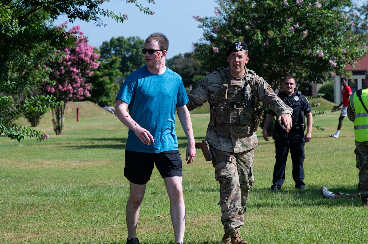 U.S. Air Force Tech. Sgt. Luke Jimerson (right), 42d Security Forces Squadron base defense noncommissioned officer in charge, escorts Senior Airman Jacob Domingue, Air Force Life Cycle Management Center developer, to a safe place in a simulated tornado response during MAXFORCE 26-03 at Maxwell Air Force Base, Alabama, July 14, 2026.