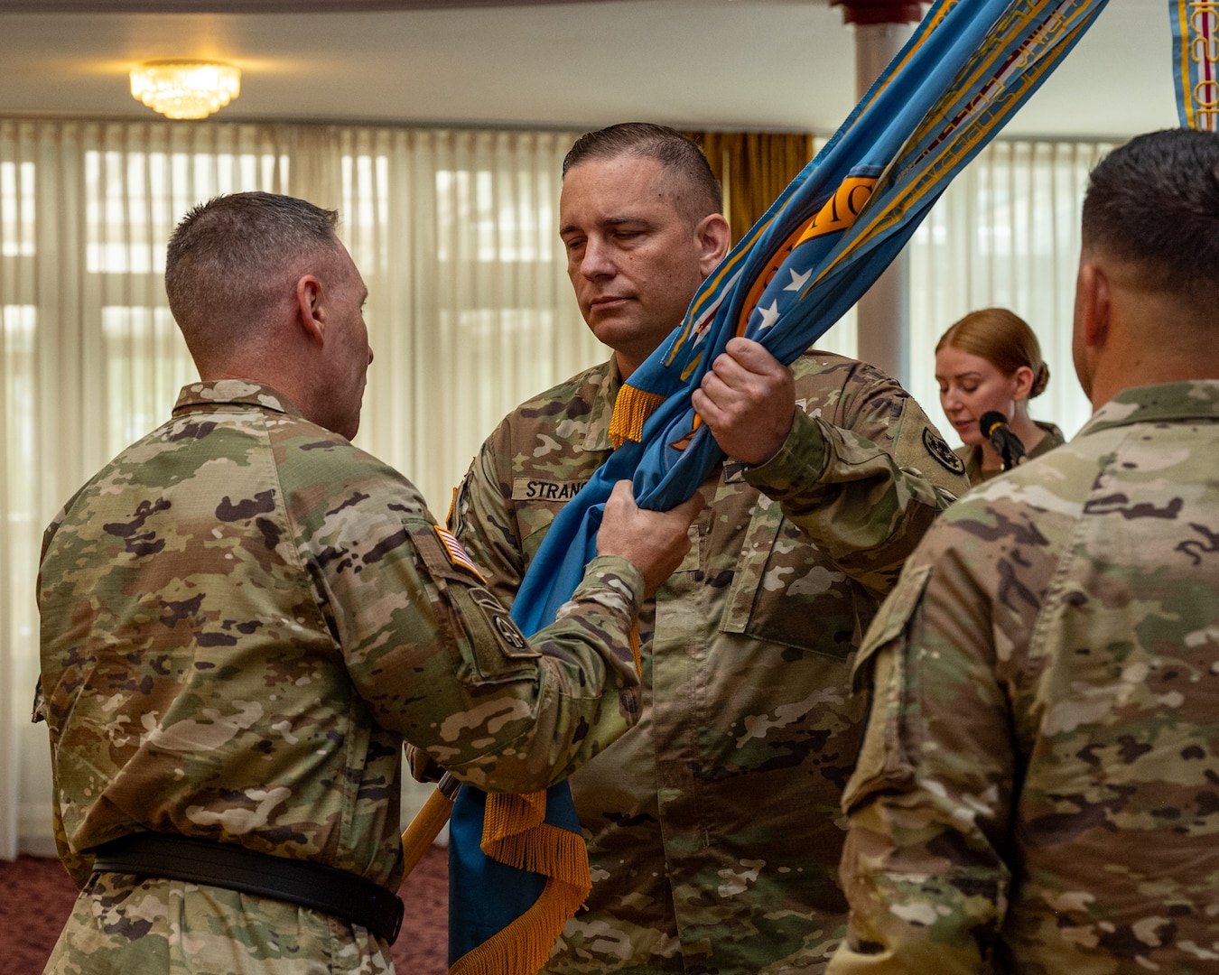 U.S. Army Brig. Gen. Sean P. Kelly, DLA Troop Support commander (left) receives the unit colors from outgoing commander, Army Lt. Col. Eduardo Rivera symbolizing that he has handed over command of DLA Troop Support Europe & Africa, June 26, 2026, at The Armstrong Club, Kaiserslautern, Germany. Rivera relinquished command of the unit, which provides food, clothing, construction materials, medical supplies and more to warfighters throughout Europe, Africa and the Middle East. Department of War photograph by Anthony Sualog.