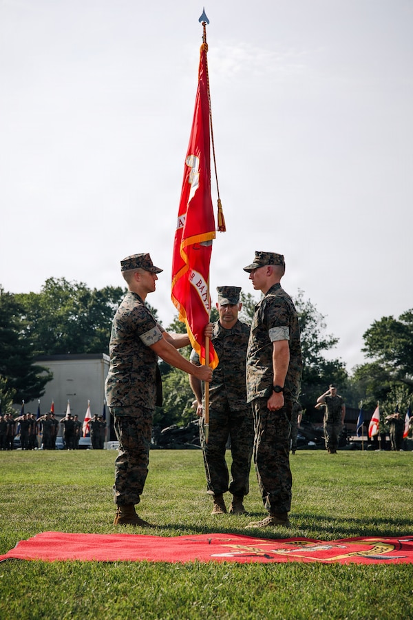 U.S. Marine Corps Lt. Col. Brian Hinrichs, the outgoing commanding officer of Combat Instructor Battalion, right, passes the colors to Lt. Col. Oryan Lopes, the incoming commanding officer of CIB during the CIB change of command ceremony at Marine Corps Base Quantico, Virginia, June 11, 2026. During the ceremony, Hinrichs relinquished command of CIB to Lopes. (U.S. Marine Corps photo by Cpl. Joshua Barker)