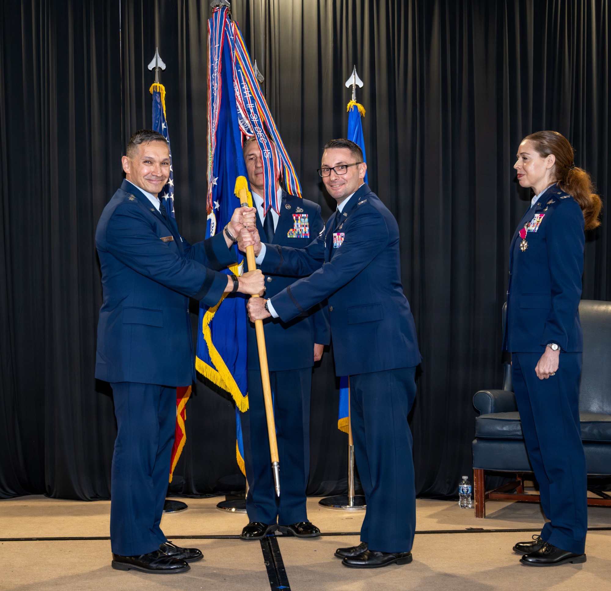 Two Airmen hold a guidon.