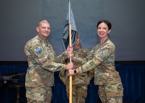Chief Master Sgt. Sarah Williams accepts the guidon from Col. Kenneth Klock.