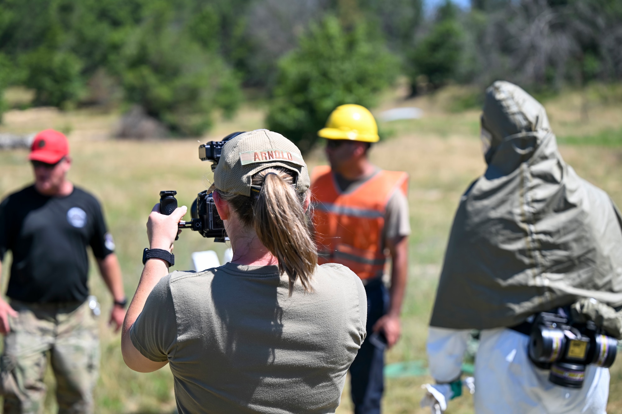 U.S. Air Force Tech. Sgt. Darby Arnold, public affairs specialist, I.G. Brown Training and Education Center University, films aircraft recovery personnel from the U.S. Air Force, U.S. Marine Corps and U.S. Navy, alongside industry and allied partners, as they prepare to survey and mark a debris field during the F-35 Joint Program Office Advanced Crash Damaged or Disabled Aircraft Recovery (CDDAR) course at Volk Field Combat Readiness Training Center, Wisconsin, July 14, 2026. The advanced CDDAR course challenged participants to solve complex recovery scenarios while improving joint integration, critical thinking and multinational interoperability. (U.S. Air National Guard photo by Master Sgt. Regina Young)