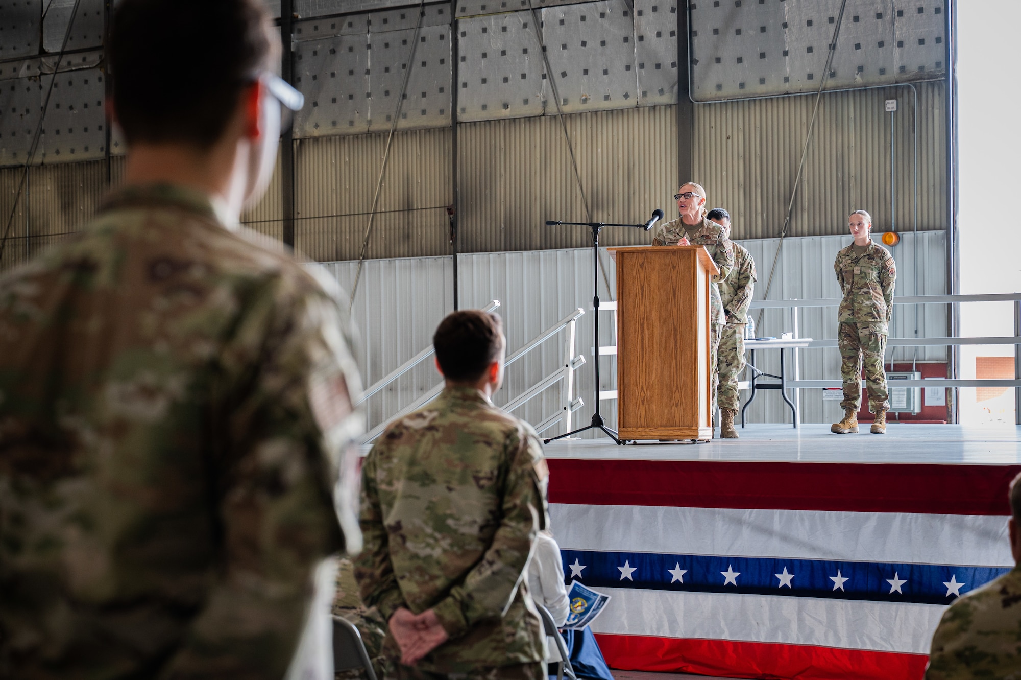 A photo of a woman standing on a stage giving a speech.