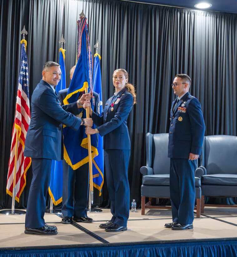 Two Airmen hold a guidon.
