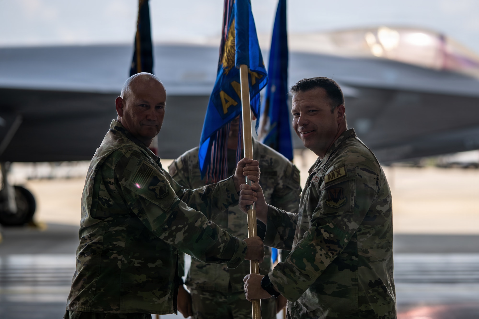 U.S. Air Force Col. Dennis Knight, 325th Maintenance Group commander, left, passes the 325th Aircraft Maintenance Squadron guidon to Maj. Donovan Ricks as he assumes command of the newly reactivated squadron during a ceremony at Tyndall Air Force Base, Florida, July 27, 2026.