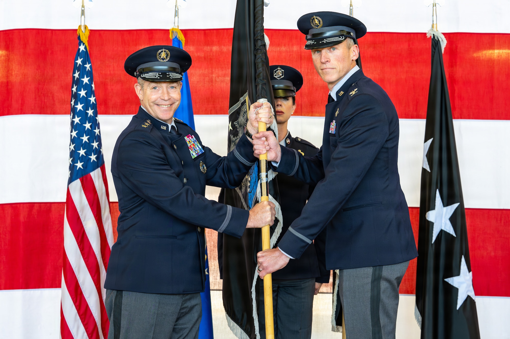 U.S. Space Force Col. Charles Cooper, incoming Space Base Delta 1 commander, accepts the guidon from Lt. Gen. Gregory Gagnon,