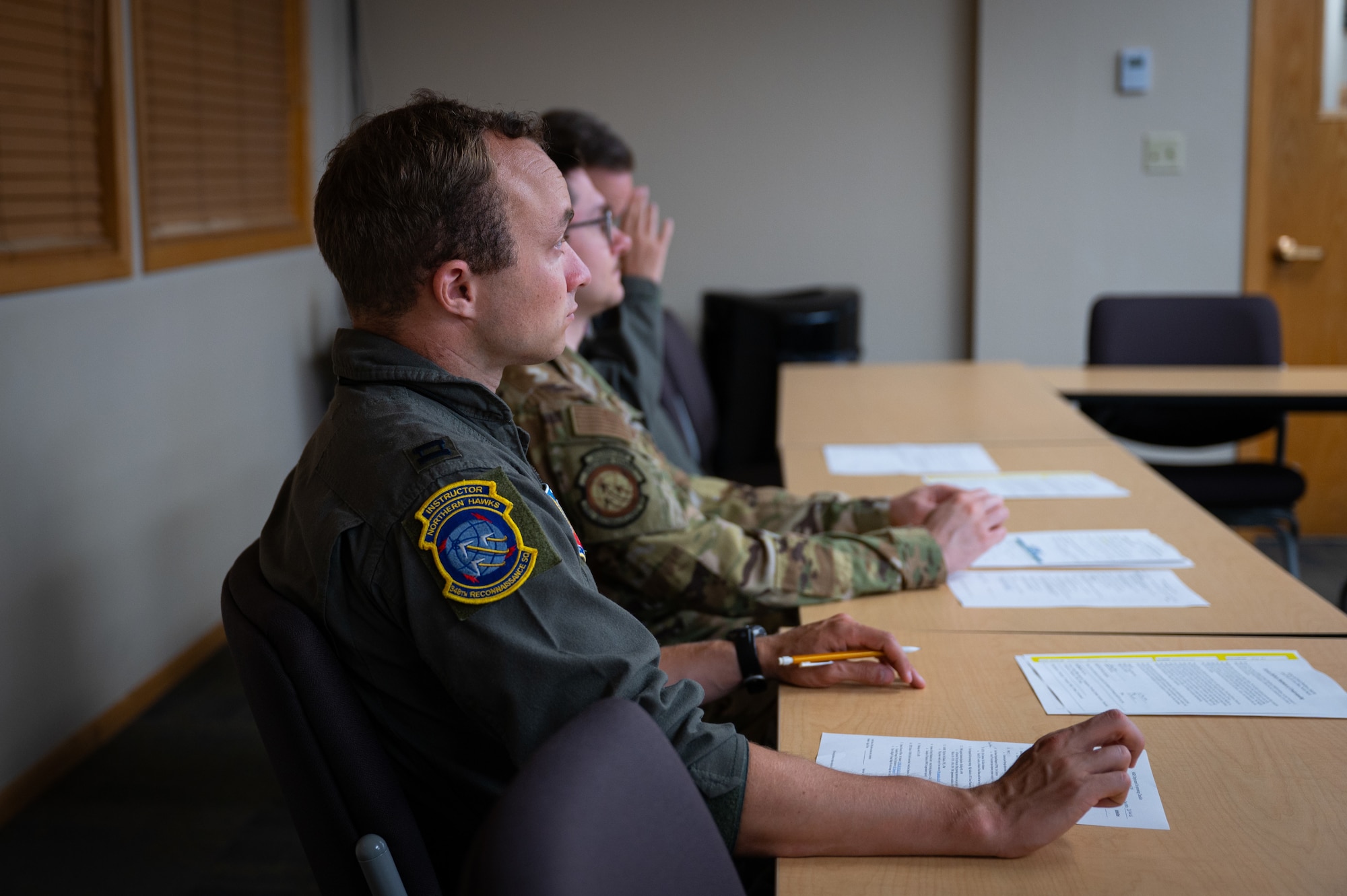 A photo of three people sitting at a table.