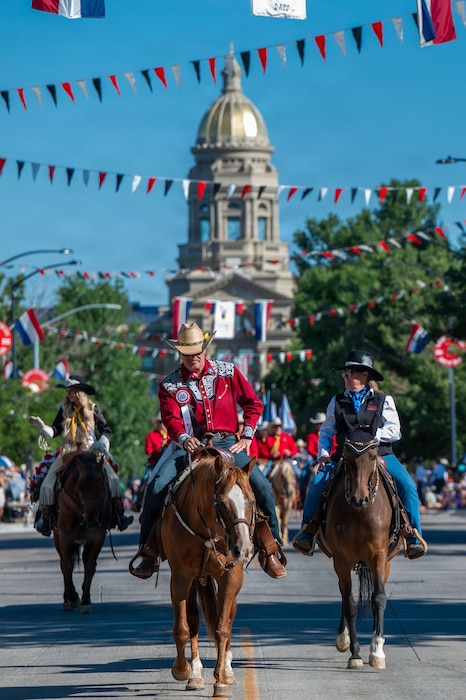 A photo of Chief Master Sergeant of the Air Force David R. Wolfe riding a horse in a parade in front of the Wyoming Capital.