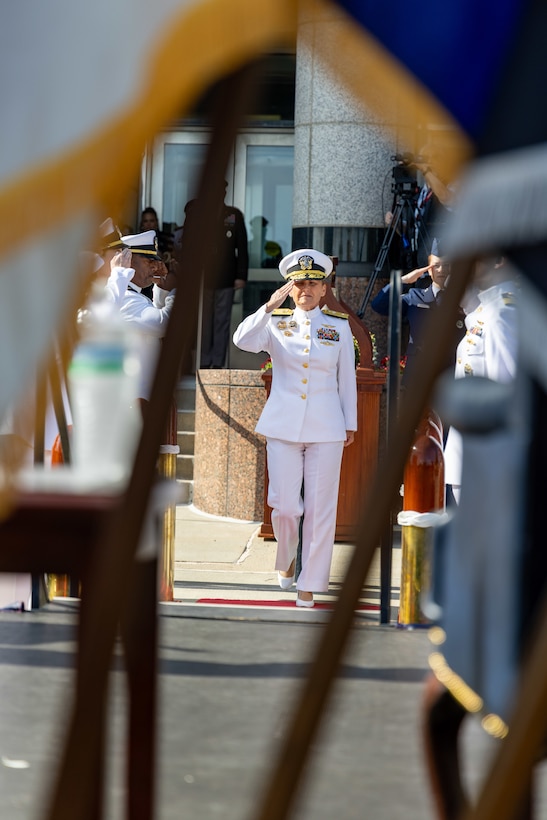 A woman in a Navy uniform salutes.