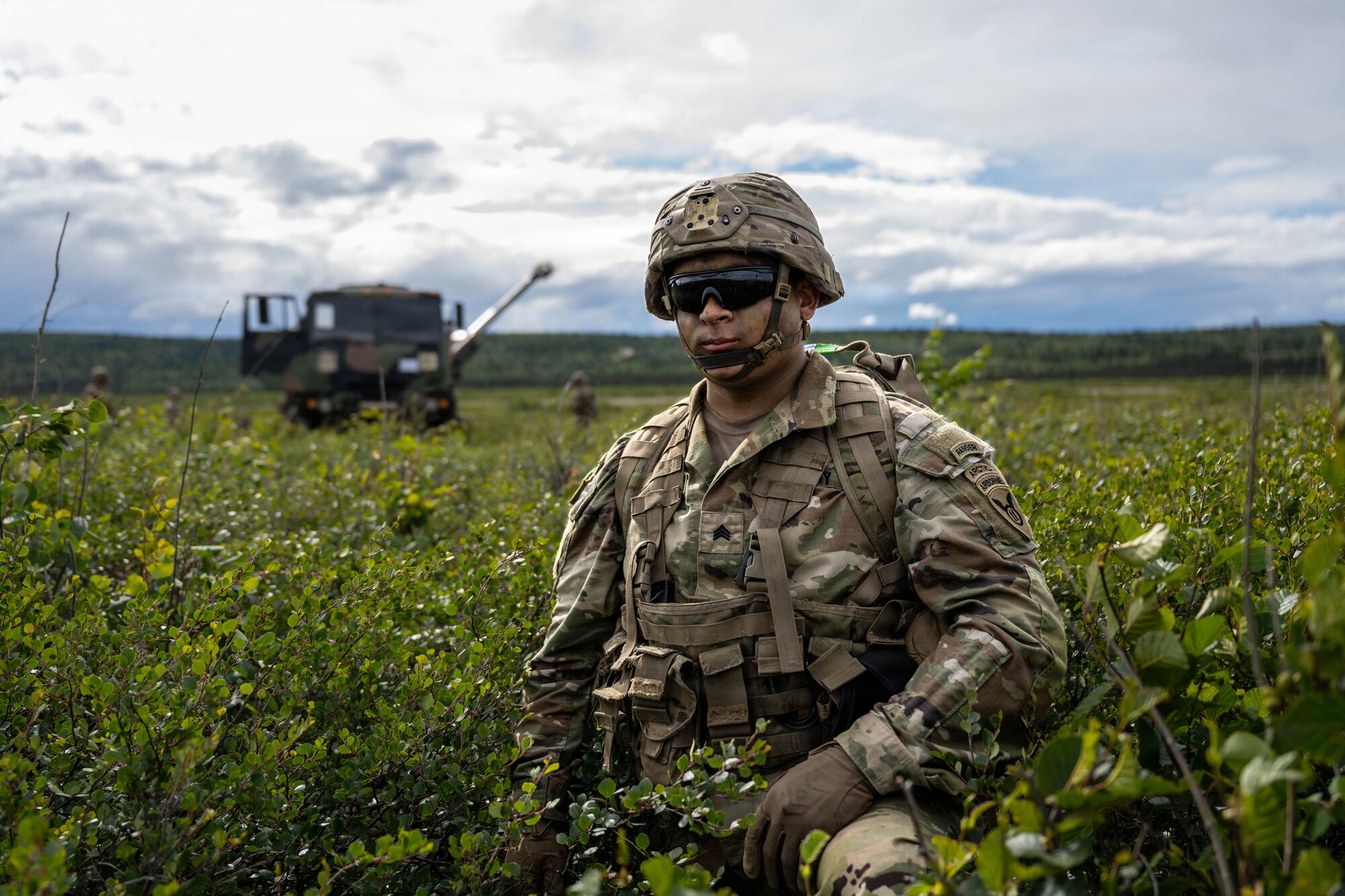 A U.S. Army Soldier assigned to the 2nd Battalion, 377th Parachute Field Artillery Regiment, 11th Airborne Division, stands watch during a dry fire exercise at Donnelly Landing Zone, Alaska, July 13, 2026. The exercise allowed Soldiers to strengthen their field artillery operations and security procedures skills in preparation for real-world contingencies. (U.S. Air Force photo by Senior Airman Lauren Torres)