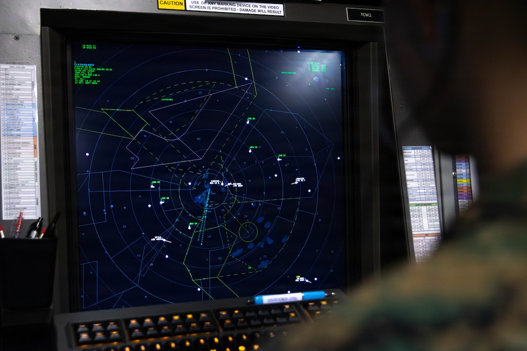 U.S. Marine Corps Sgt. Austin Tomarchio, an air traffic controller with Headquarters and Headquarters Squadron (HHS), Marine Corps Air Station Iwakuni, and a native of Nashville, Tennessee, observes radar signatures in the radar room at MCAS Iwakuni, Japan, March 31, 2026. Sgt. Austin Tomarchio was the primary subject for a story about air traffic controllers stationed at MCAS Iwakuni. (U.S. Marine Corps Photo by Lance Cpl. Dugger)