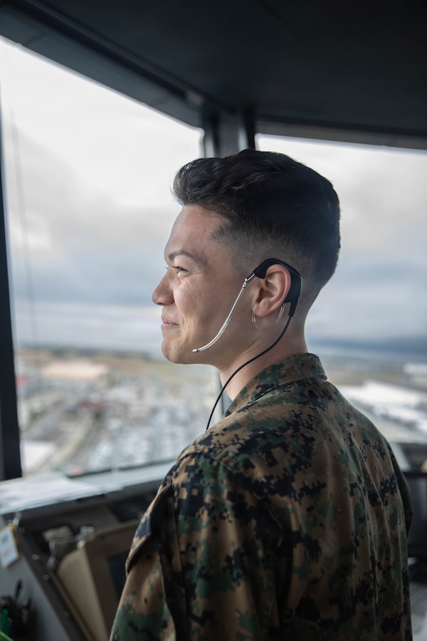 U.S. Marine Corps Sgt. Austin Tomarchio, an air traffic controller with Headquarters and Headquarters Squadron (HHS), Marine Corps Air Station Iwakuni, and a native of Nashville, Tennessee, observes aircraft movement on the flightline at MCAS Iwakuni, Japan, March 31, 2026. Sgt. Austin Tomarchio was the primary subject for a story about air traffic controllers stationed at MCAS Iwakuni. (U.S. Marine Corps Photo by Lance Cpl. Dugger)