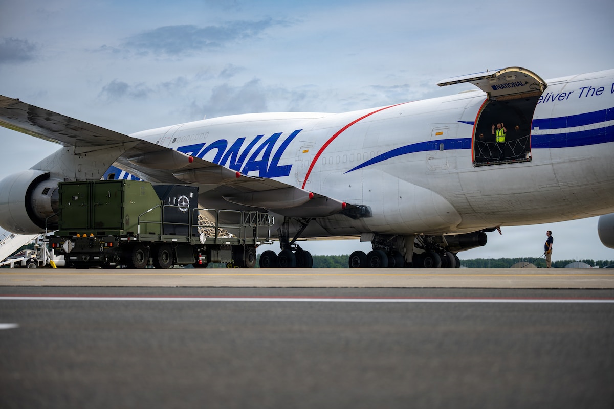 An aircraft cargo loader and transporter moves towards a Boeing 747 transport aircraft in support of Red Flag-Alaska 26-3.