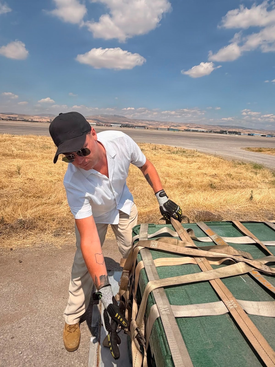 Person checking straps on equipment