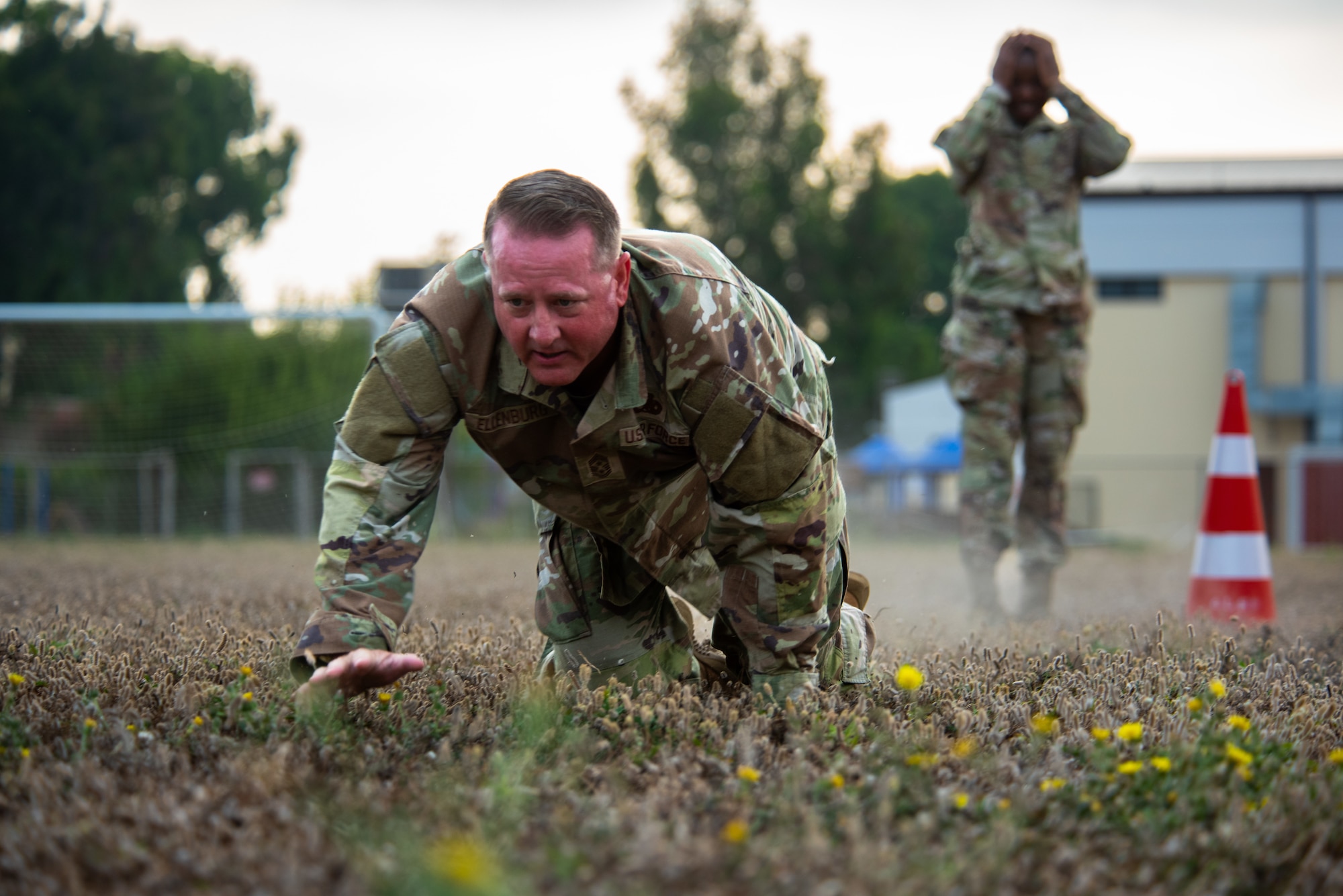 U.S. Air Force Chief Master Sgt. Sean Ellenburg, 39th Air Base Wing command chief, low crawls through an obstacle.