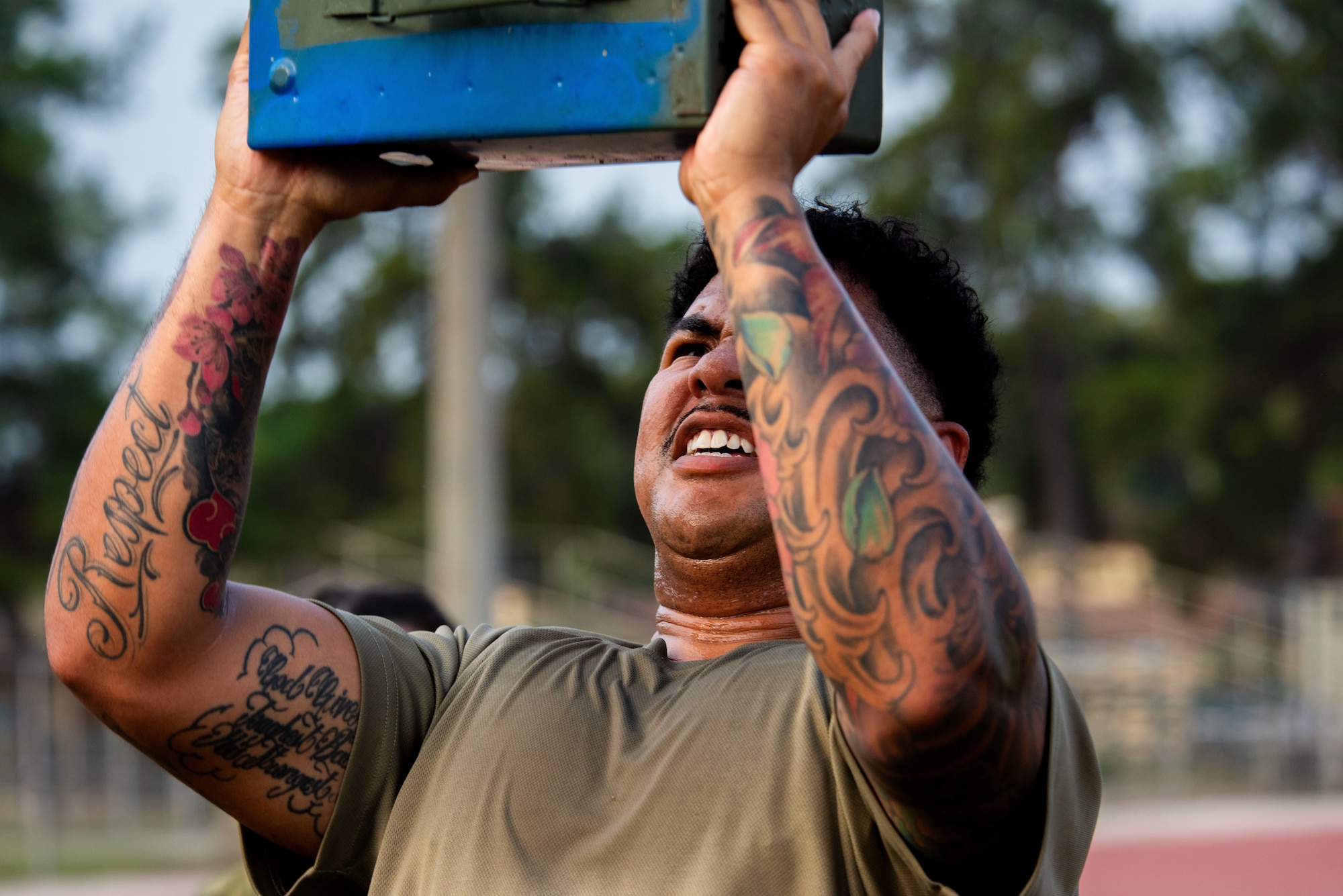 U.S. Air Force Senior Airman Kris Pham, an Airman Leadership School student, lifts an ammunition can.