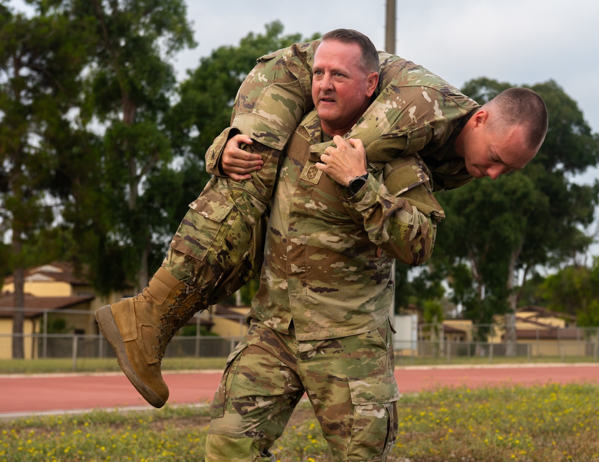 U.S. Air Force Chief Master Sgt. Sean Ellenburg, 39th Air Base Wing command chief, fireman carries Senior Airman Cougar Heiny, an Airman Leadership School student.