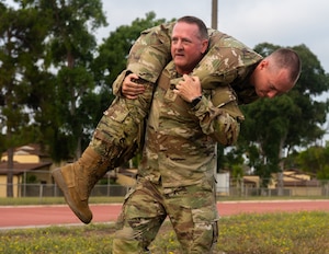 U.S. Air Force Chief Master Sgt. Sean Ellenburg, 39th Air Base Wing command chief, fireman carries Senior Airman Cougar Heiny, an Airman Leadership School student.