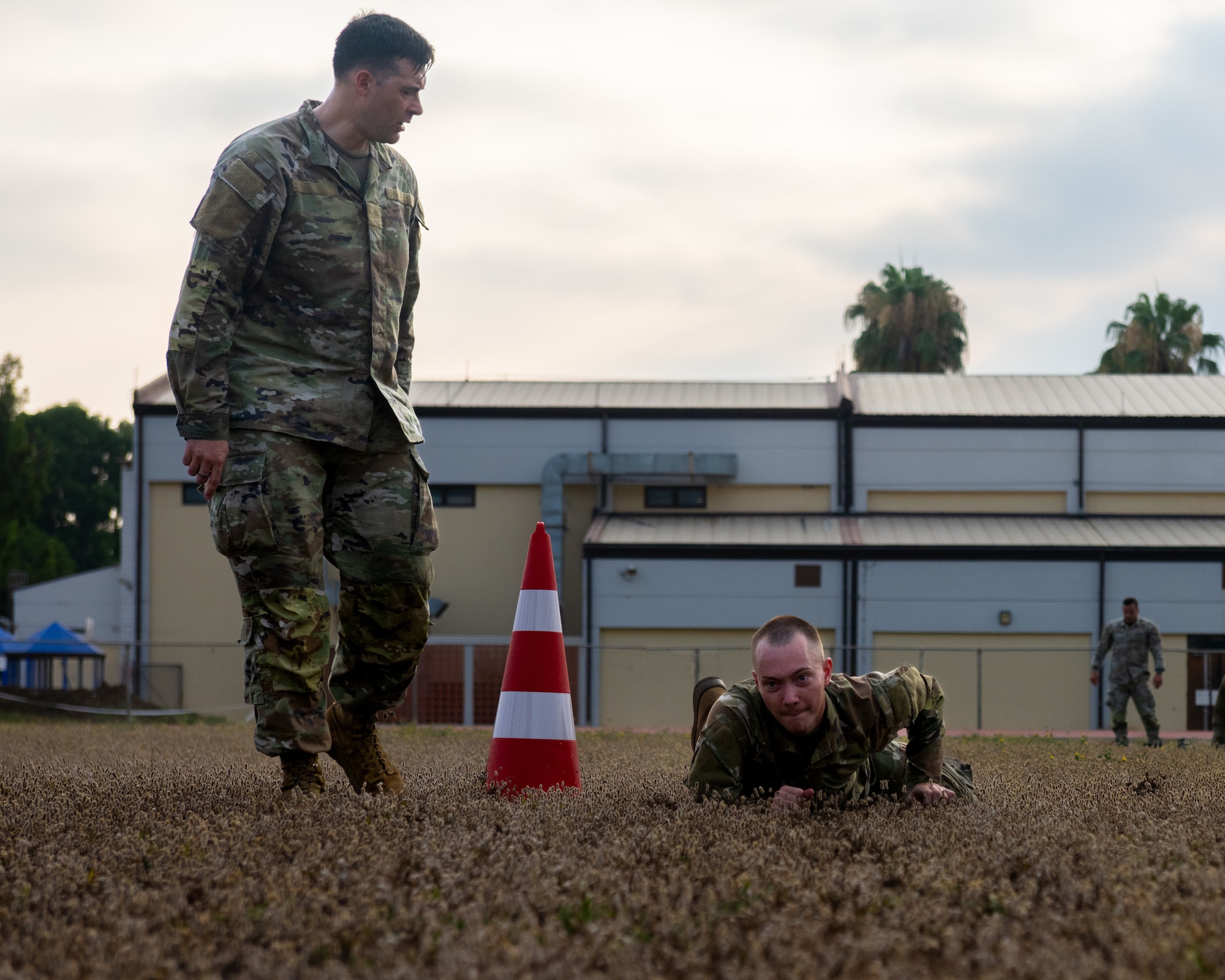 U.S. Air Force Tech. Sgt. Chance Stone, 39th Force Support Squadron Airman Leadership School instructor, observes Senior Airman Cougar Heiny, an ALS student, low crawl through an obstacle.