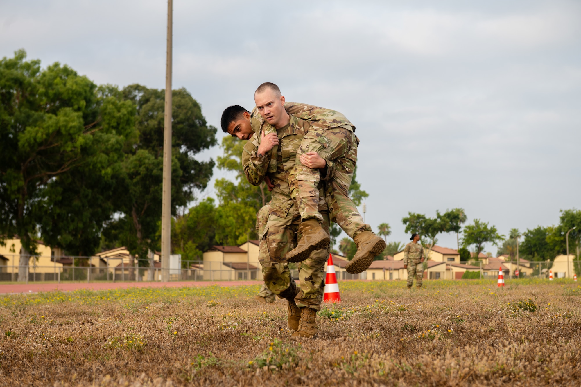 U.S. Air Force Senior Cougar Heiny, an Airman Leadership School student, carries Senior Airman Kevin Cruz, an ALS student.