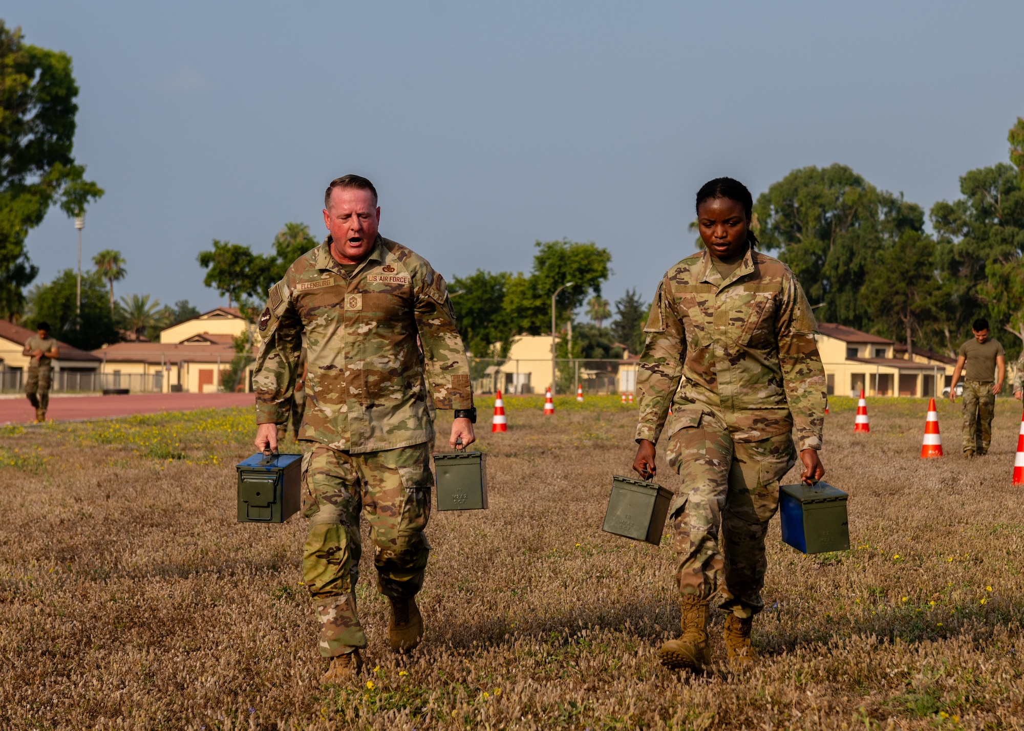 U.S. Air Force Chief Master Sgt. Sean Ellenburg, 39th Air Base Wing command chief, and Senior Airman Rashkaina Mertilien, an Airman Leadership School student, carry ammunition cans.