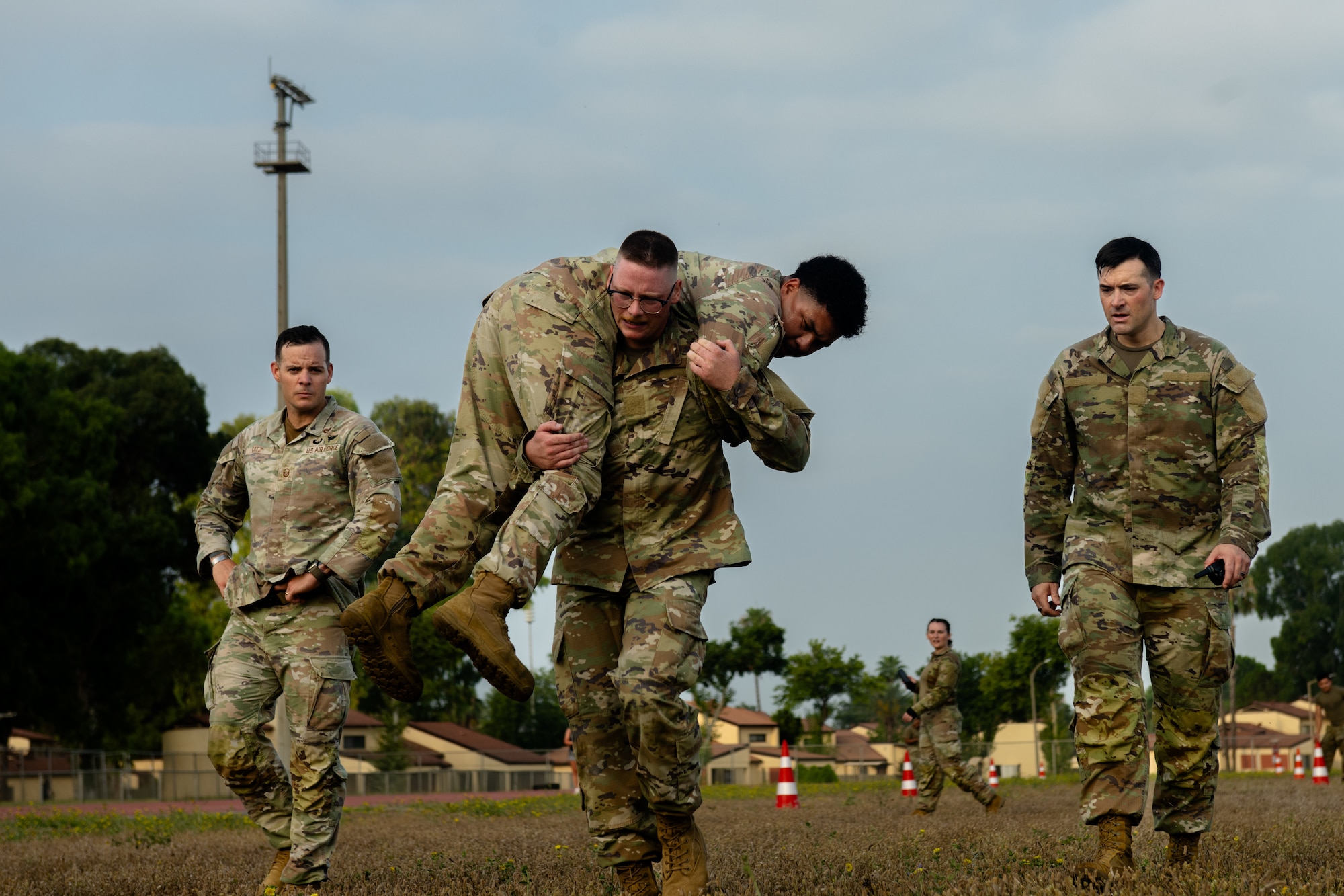 U.S. Air Force Jacob O’Grady, an Airman Leadership School student, fireman carries Senior Airman Kris Pham, and ALS student.