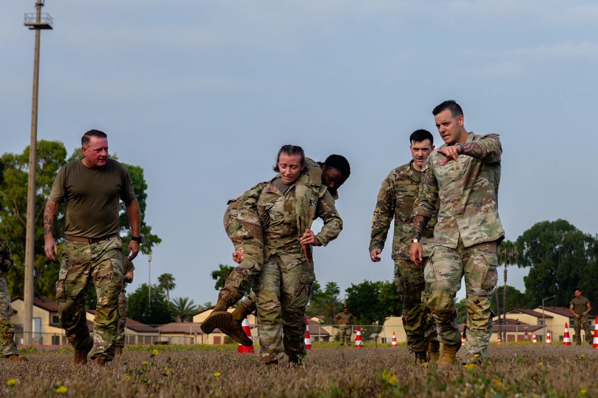 U.S. Air Force Senior Airman Brooklyn Clark, an Airman Leadership School student, carries Senior Airman Rashkaina Mertilien, an ALS student.