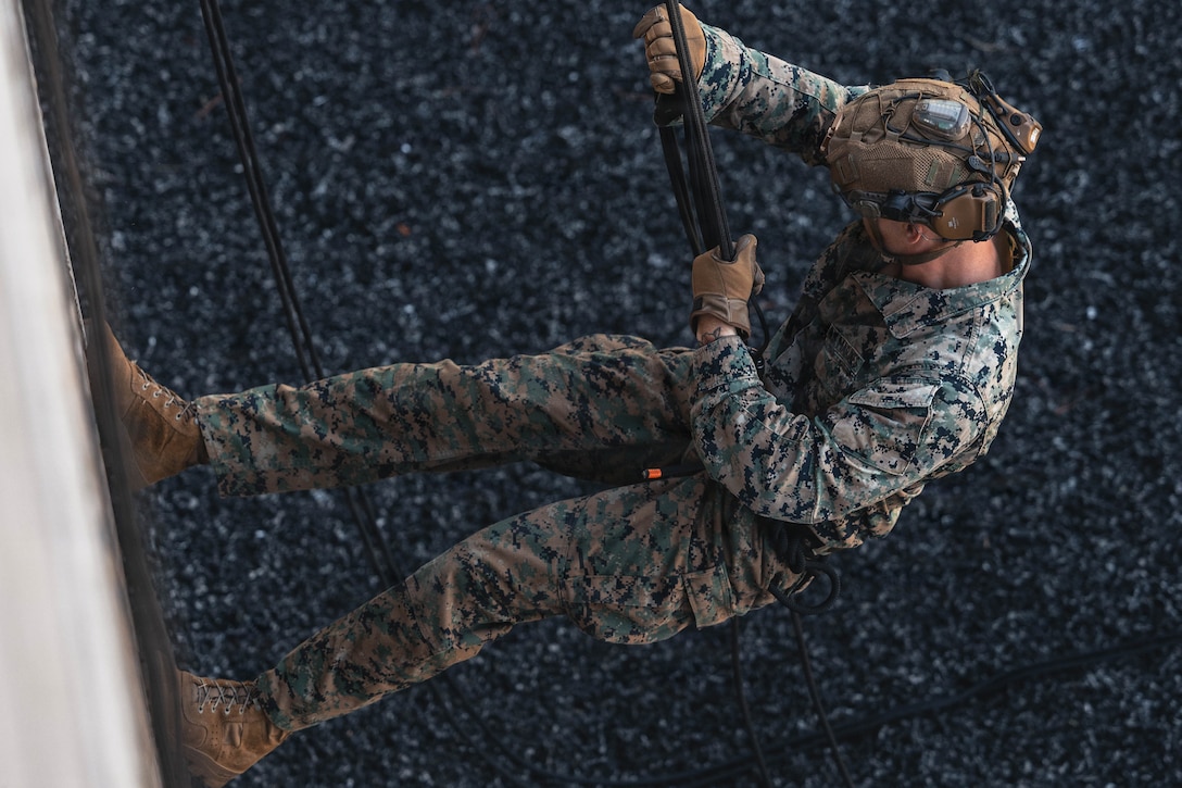 A U.S. Marine with 2nd Reconnaissance Battalion rappels down a training structure during a helicopter rope suspension techniques course on Marine Corps Base Camp Lejeune, North Carolina, July 15, 2026. The HRST training prepares Marines to navigate difficult terrain and insert rapidly into contested areas through rappelling and fast-rope descents. (U.S. Marine Corps photo by Sgt. Jorge Borjas)