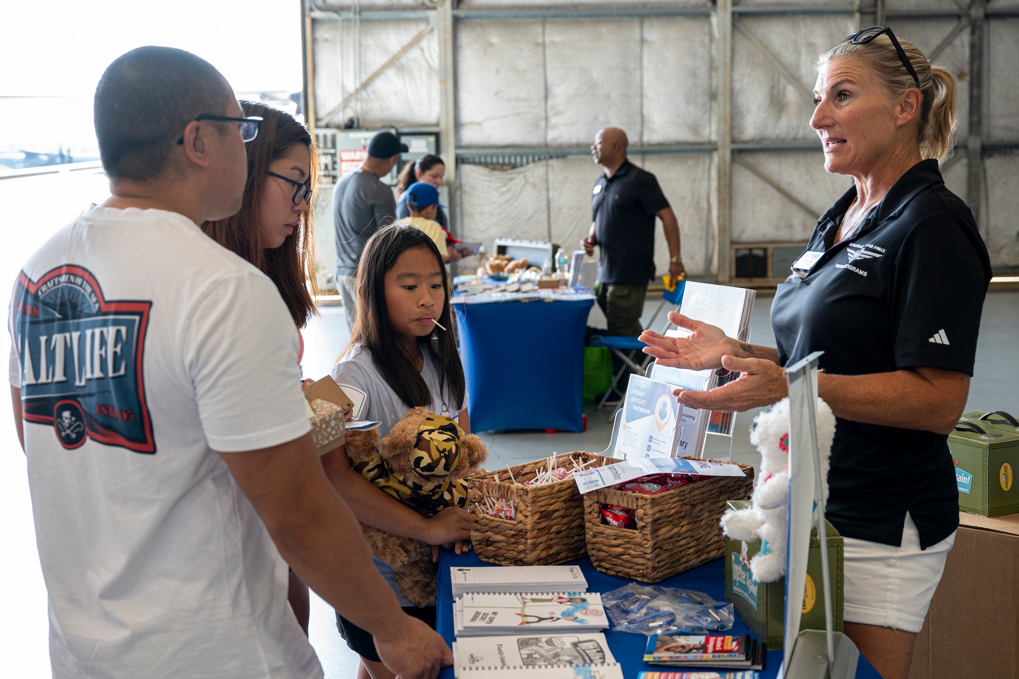 An Airman assigned to the 1st Special Operations Wing and his family, left, speaks with Dr. Mackinley Cross, Hurlburt Field school liaison, during an Operation Discovering and Exploring Military Operations homecoming event at Hurlburt Field, Florida, June 27, 2026.