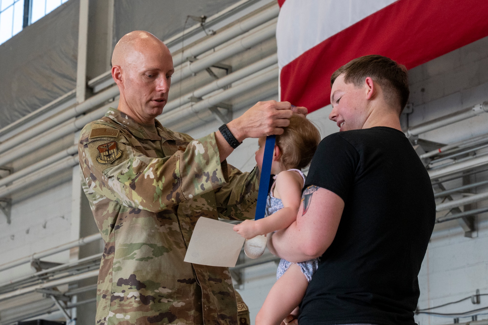 Col. William Smith, 1st Special Operations Mission Support Group commander, presents a medal to a child during an Operation Discovering and Exploring Military Operations homecoming event at Hurlburt Field, Florida, June 27, 2026.
