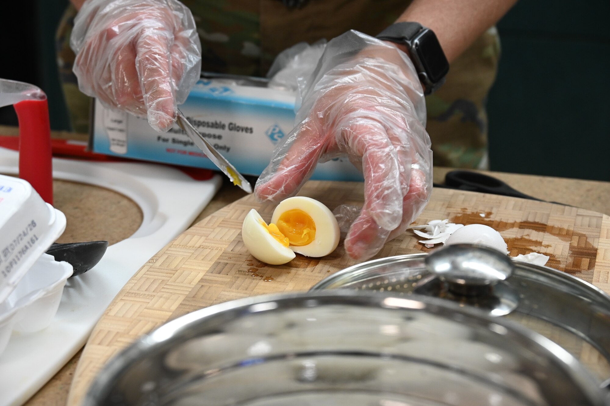 U.S. Air Force Capt. Rebekah Suggs, Laughlin Medical Group operational support team dietitian, slices open a soft-boiled egg during the Cooking Connections cooking class at Laughlin Air Force Base, Texas, July 23, 2026. Suggs used the egg as part of a ramen recipe taught in the Cooking Connections class. (U.S. Air Force photo by Airman 1st Class Kylie Rabb)