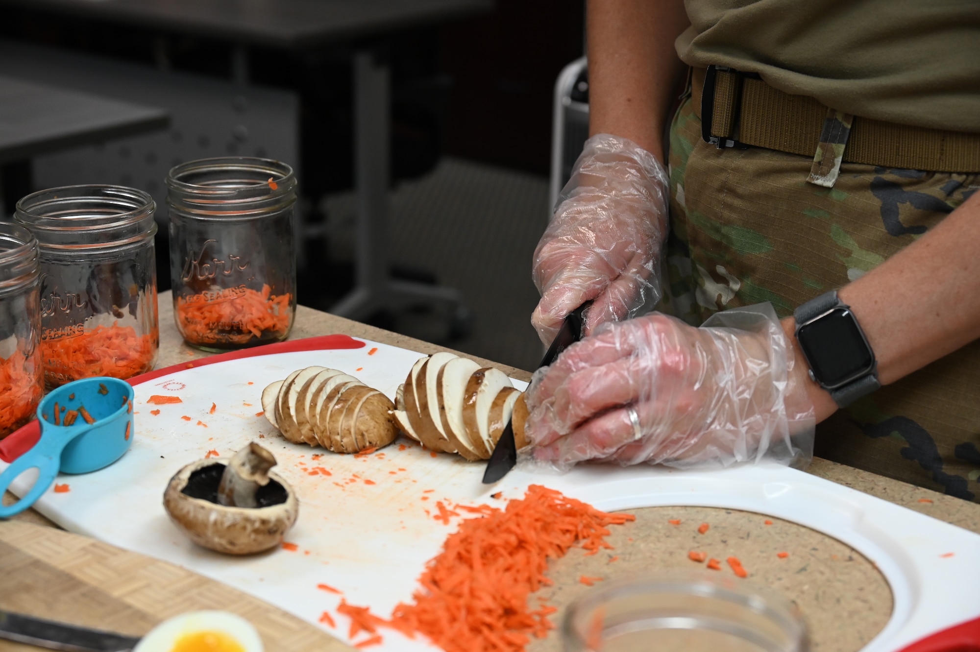 U.S. Air Force Capt. Rebekah Suggs, Laughlin Medical Group operational support team dietitian, slices mushrooms for a ramen recipe during the Cooking Connections cooking class at Laughlin Air Force Base, Texas, July 23, 2026. Suggs educated participants on three unique recipes involving ramen noodles. (U.S. Air Force photo by Airman 1st Class Kylie Rabb)