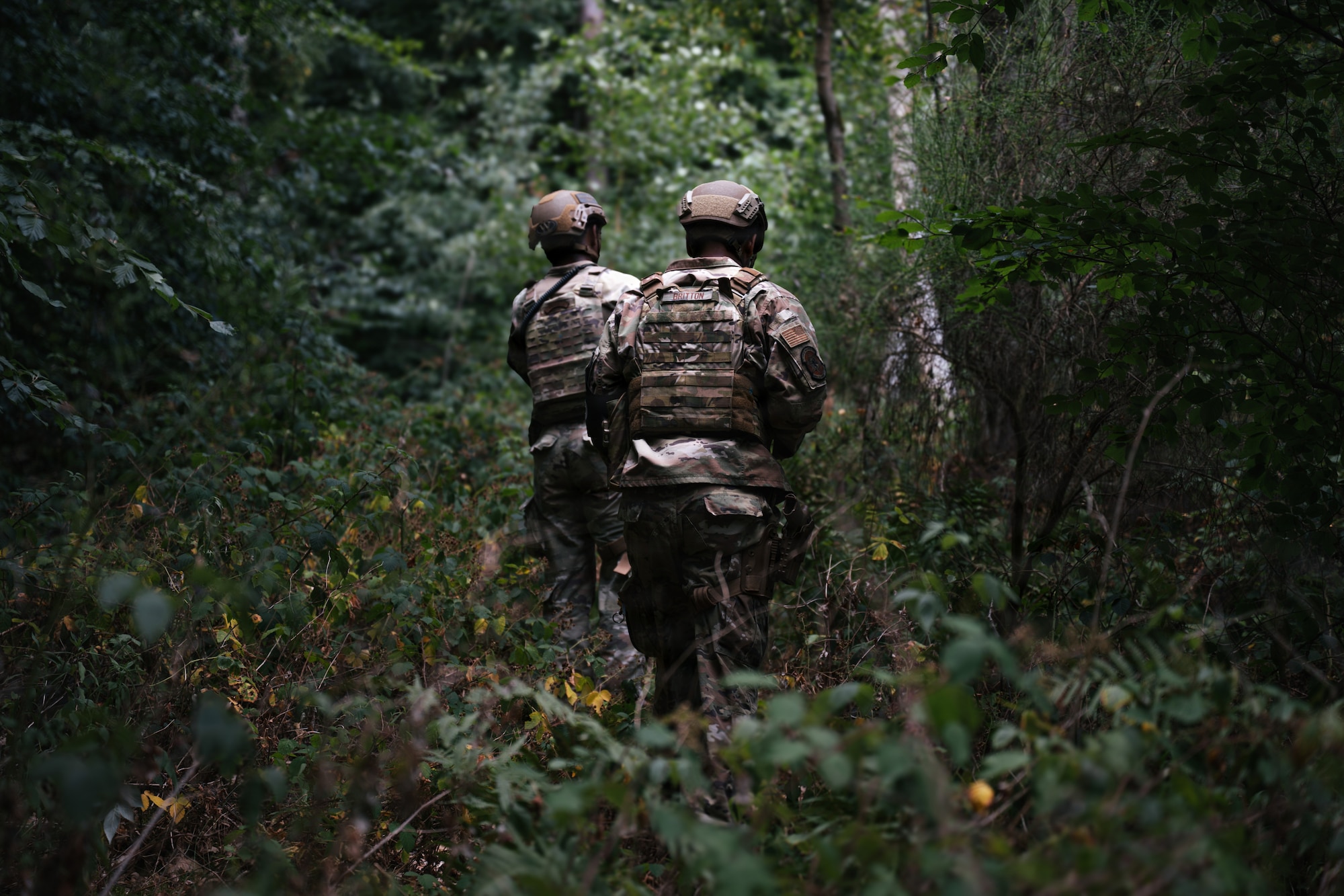U.S. Air Force Senior Airman Rodney Richburg, 569th U.S. Forces Police Squadron patrolman, and Staff Sgt. Caleb Britton, 569th UFPS desk sergeant, scout through the woods at Kapaun Air Station, Germany, July 23, 2026.