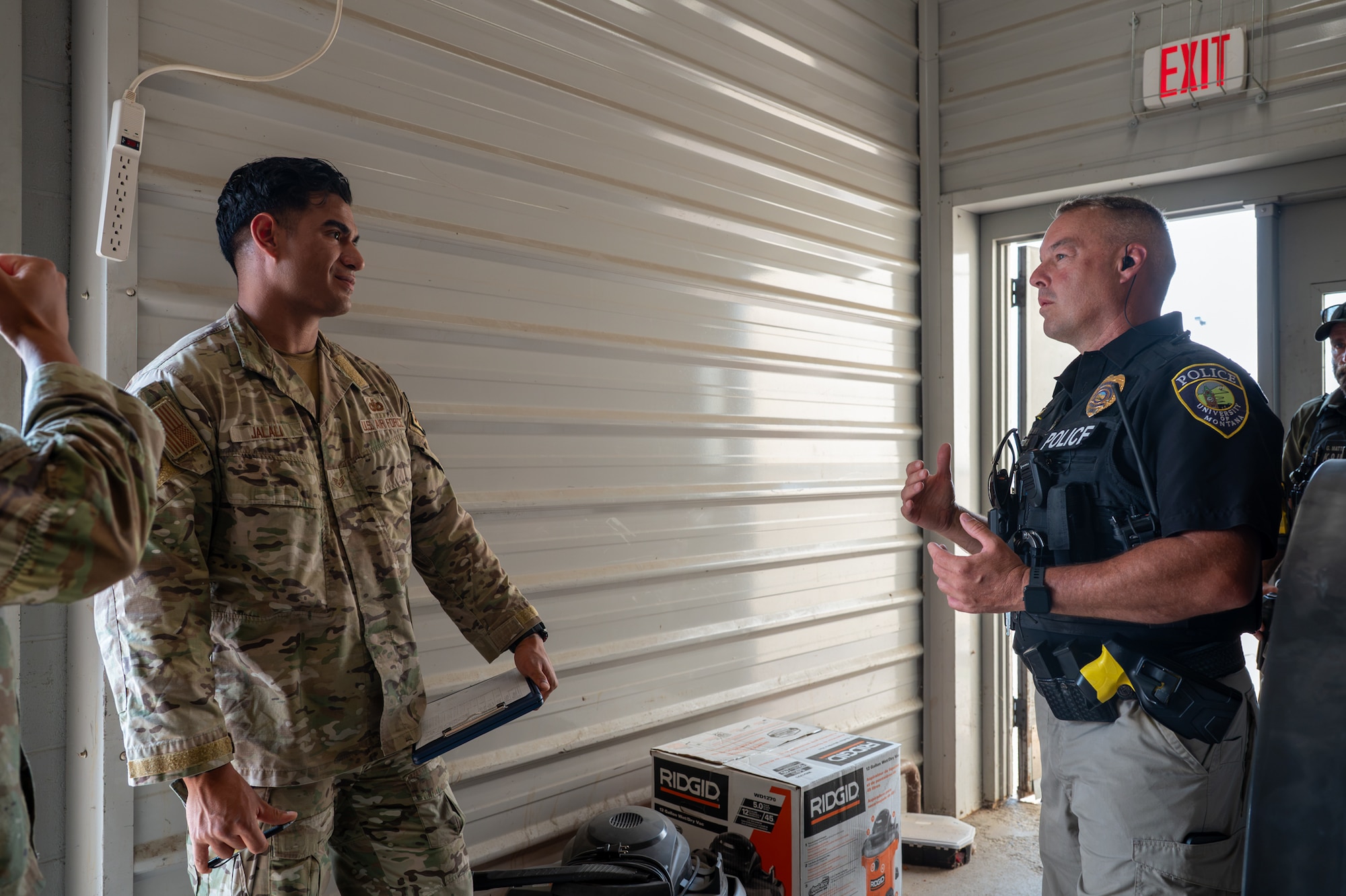 A U.S. Air Force military working dog handler talks to a local police officer.