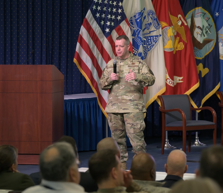 Air Force Maj. Gen. David Sanford, the director of DLA Logistics Operations, stands on stage and addresses an audience gathered at the headquarters auditorium.