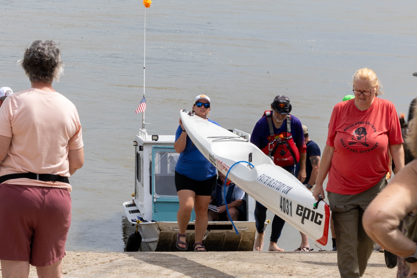 People carrying boat on dock.