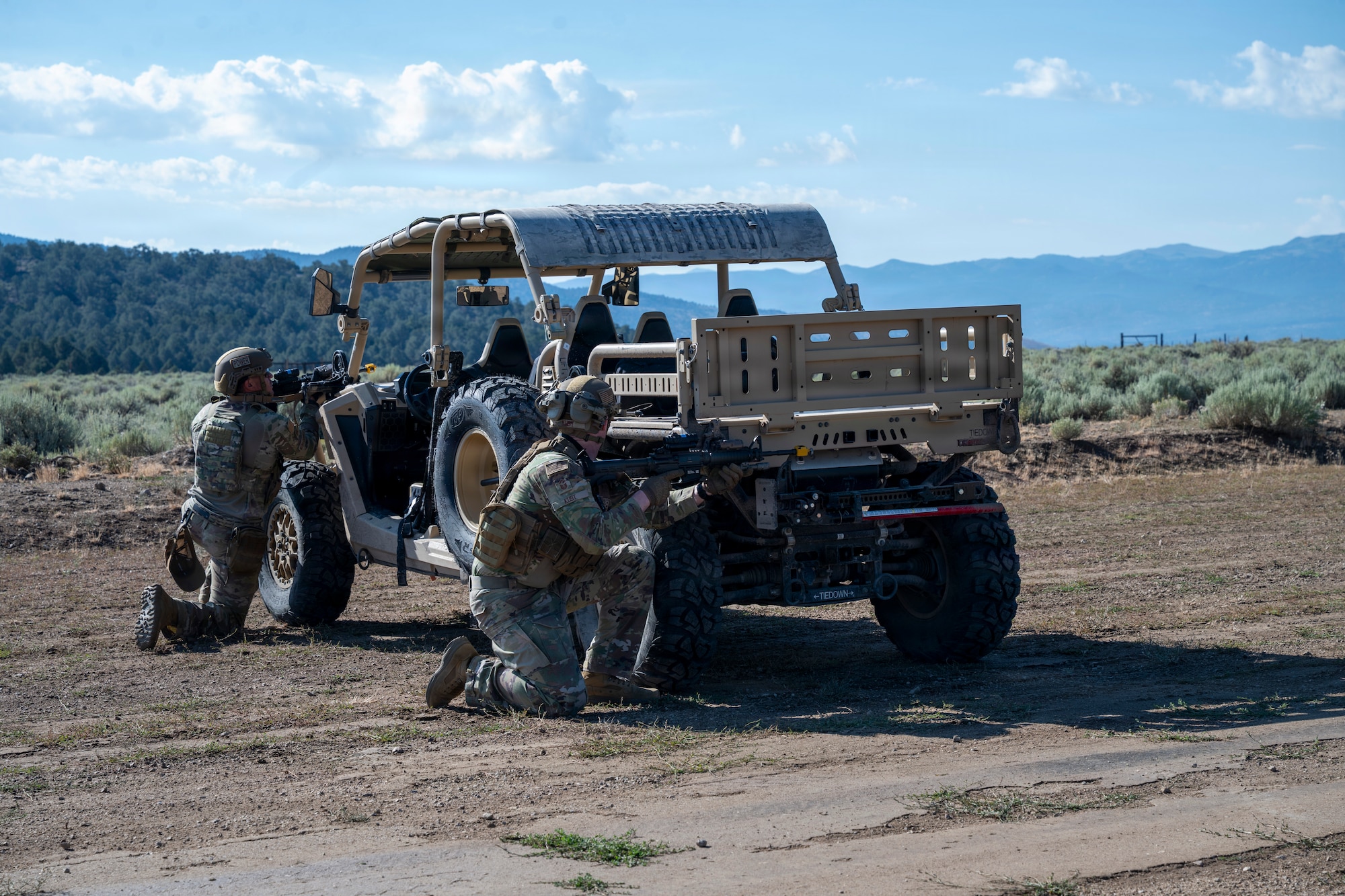 Airmen take position around a vehicle during training.