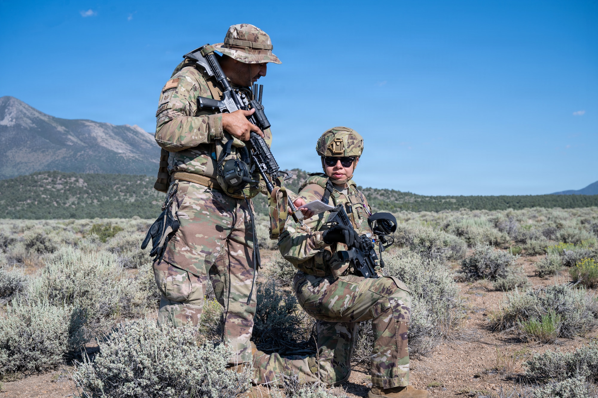 Two Airmen hold their weapons during training.