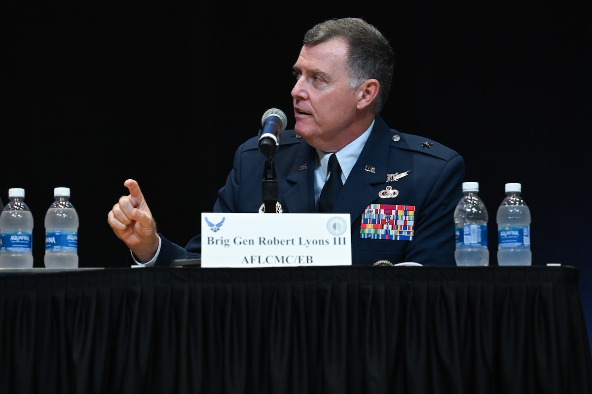 White male Air Force Brig. Gen. sits at table wearing dress blues.