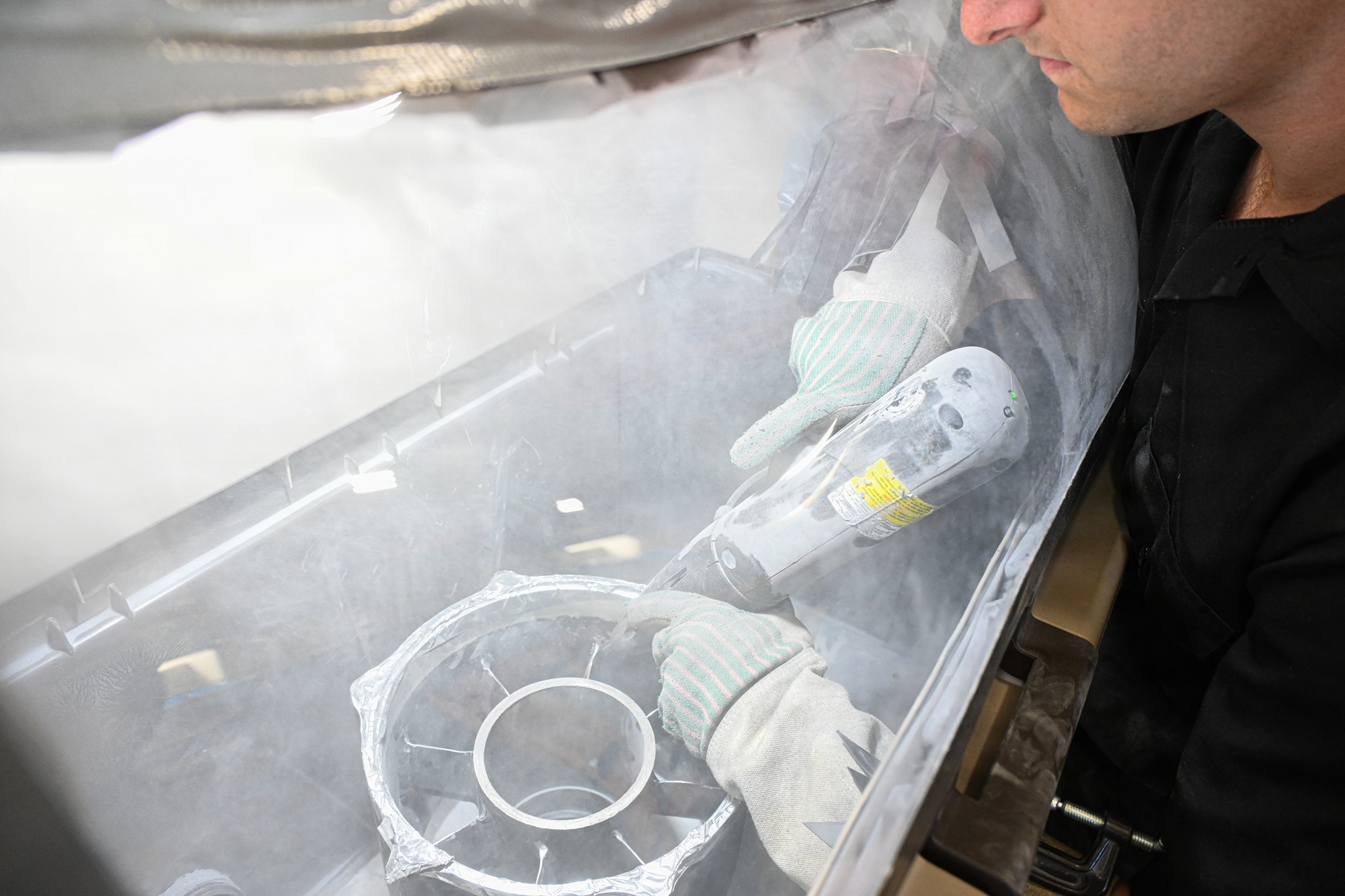 U.S. Marine Corps Pfc. Kaden Hicks, an automotive maintenance technician with Intermediate Repair Company, 3rd Maintenance Battalion, 3rd Marine Logistics Group, sprays a stator housing for an Evinrude boat motor using cold spray technology during Valiant Shield 26 on Camp Kinser, Okinawa, Japan, June 22, 2026. Intermediate Repair Company participated in Resilient Advanced Manufacturing for Contested Environments, or RAMFORCE, an initiative hosted by the Office of the Under Secretary of Defense for Research and Engineering. The innovative event brought together military personnel, government laboratories, and private industry to evaluate how advanced manufacturing technologies could enable expeditionary forces to repair, replace and even produce critical equipment at the point of need. (U.S. Marine Corps photo by Cpl. Rachel Mason)