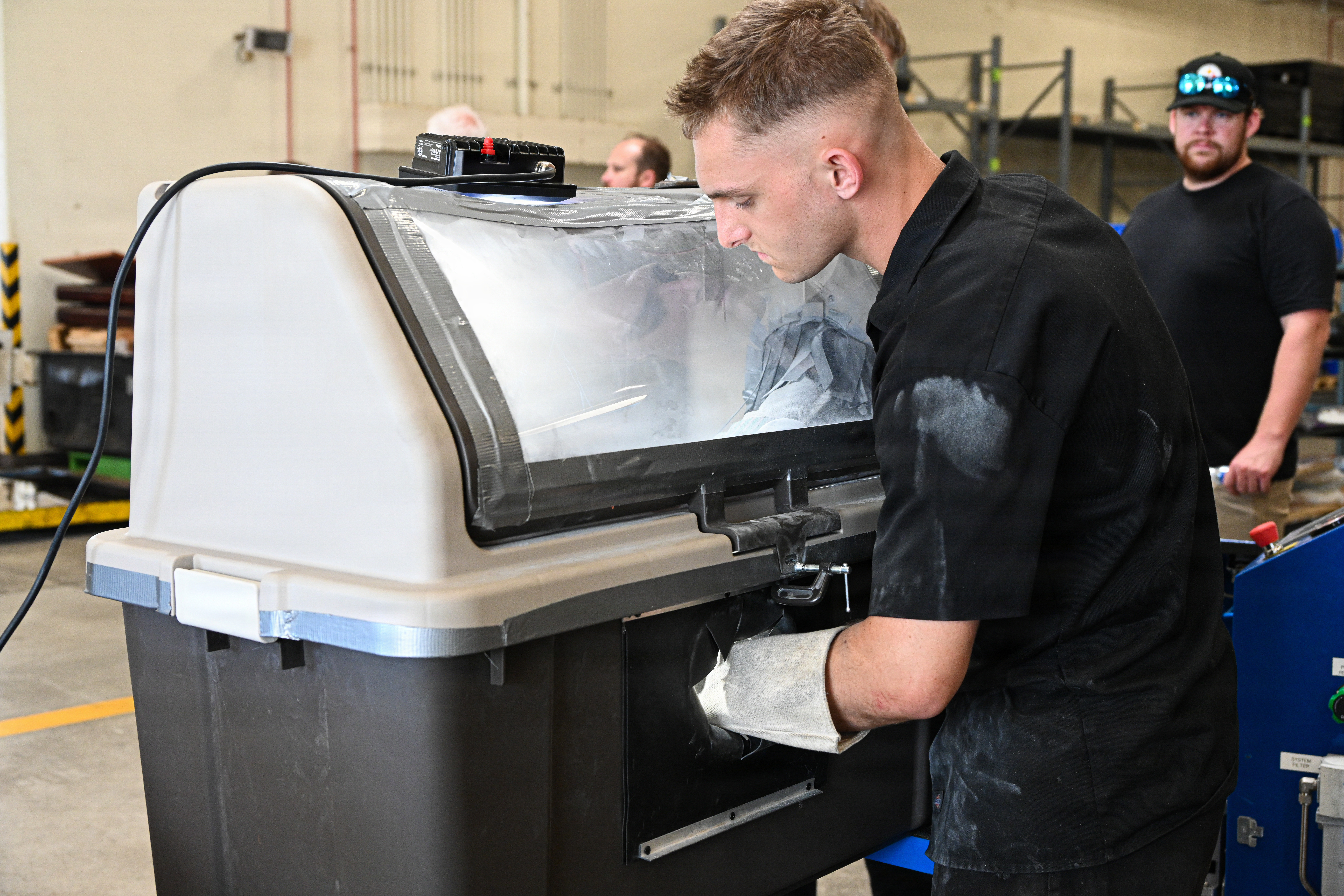 U.S. Marine Corps Pfc. Kaden Hicks, an automotive maintenance technician with Intermediate Repair Company, 3rd Maintenance Battalion, 3rd Marine Logistics Group, sprays a stator housing for an Evinrude boat motor using cold spray technology during Valiant Shield 26 on Camp Kinser, Okinawa, Japan, June 22, 2026. Intermediate Repair Company participated in Resilient Advanced Manufacturing for Contested Environments, or RAMFORCE, an initiative hosted by the Office of the Under Secretary of Defense for Research and Engineering. The innovative event brought together military personnel, government laboratories, and private industry to evaluate how advanced manufacturing technologies could enable expeditionary forces to repair, replace and even produce critical equipment at the point of need. (U.S. Marine Corps photo by Cpl. Rachel Mason)