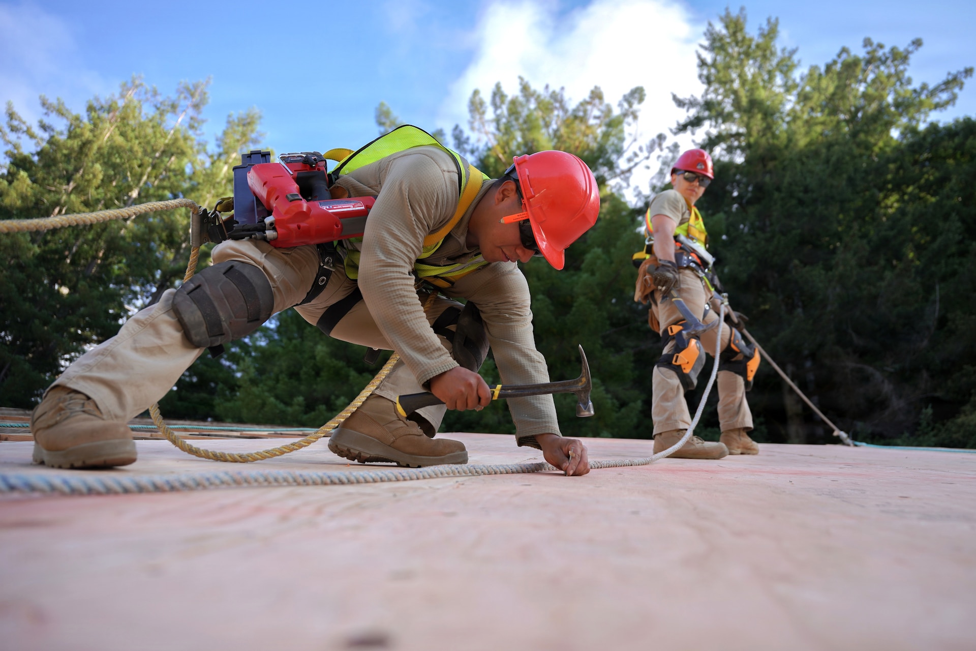 U.S. Air Force Airman 1st Class Henry Bendzin, a structures journeyman, and Tech. Sgt. Caleb Yinger, a structures craftsman, both assigned to the 201st Rapid Engineer Deployable Heavy Operational Repair Squadron Engineers, Pennsylvania Air National Guard, install plywood roof sheathing at Redwood National and State Parks near Orick, California, July 16, 2026. Their coordinated placement kept the plywood aligned across the roof deck before it was secured. (U.S. Air National Guard photo by Airman 1st Class Austin Stern)