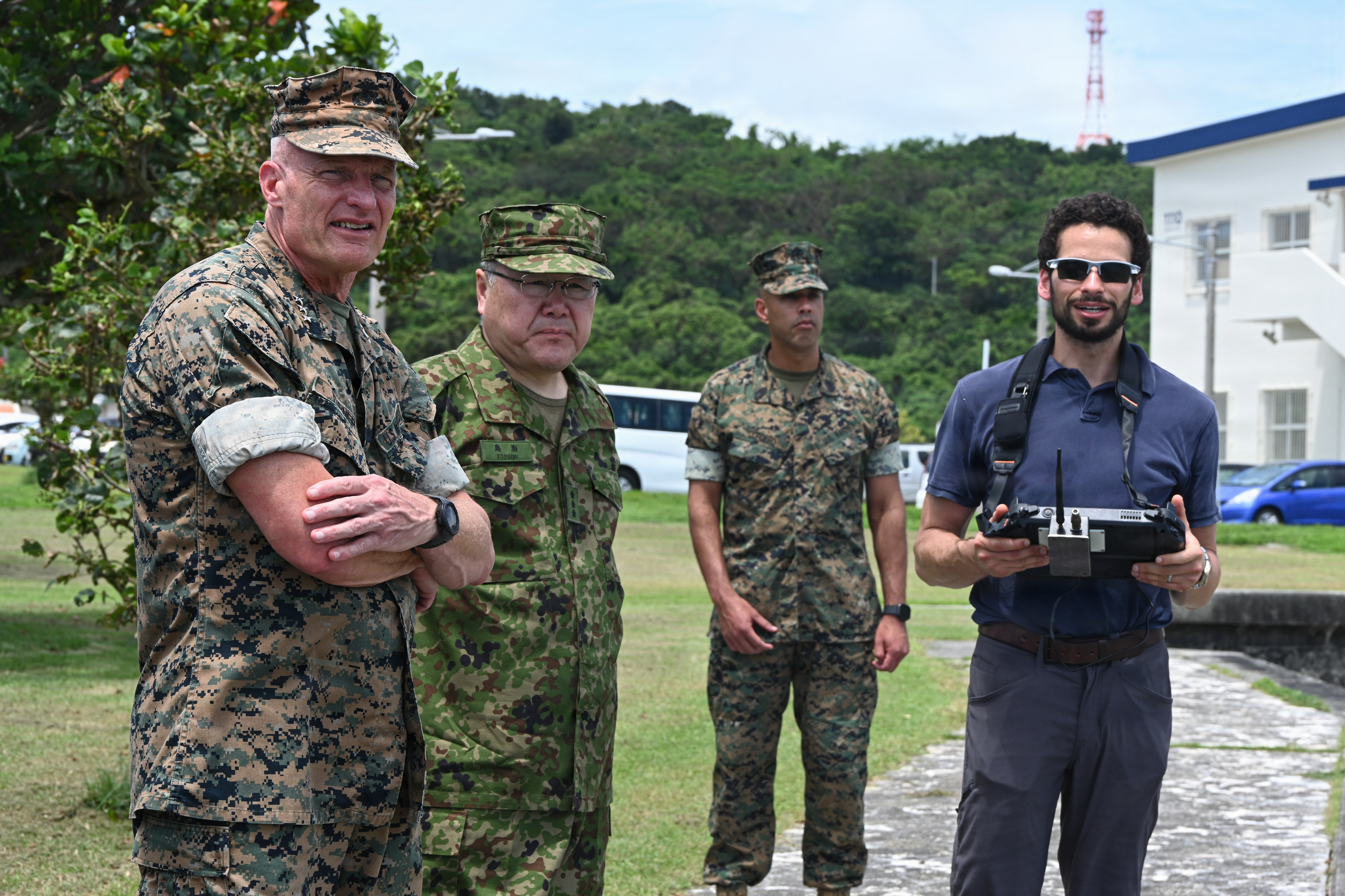 Ben Gordon, right, a Department of Navy civilian from Naval Surface Warfare Center Carderock, showcases the operation of a Configurable Budget Autonomous Swarming Submersible for Japan Ground Self-Defense Force Lt. Gen. Seiji Toriumi, second from left, commanding general of Western Army, and U.S. Marine Corps Lt. Gen. Roger Turner, left, Commanding General of III Marine Expeditionary Force, during Valiant Shield 26 at White Beach, Okinawa, Japan, June 29, 2026. C-BASS is a developmental unmanned underwater vehicle used for collecting bathymetry to support beach landing operations. Marines from 9th Engineer Support Battalion, 3rd Marine Logistics Group; 3rd Reconnaissance Battalion, 3rd Marine Division; 3rd Intelligence Battalion, III Marine Expeditionary Force; and U.S. Marine Corps Forces, Pacific, participated in operator training led by Department of Navy civilians from Naval Surface Warfare Center Carderock. The training was part of Resilient Advanced Manufacturing for Contested Environments, or RAMFORCE, an initiative hosted by the Office of the Under Secretary of Defense for Research and Engineering. The innovative event brought
together military personnel, government laboratories, and private industry to evaluate how advanced manufacturing technologies could enable expeditionary forces to repair, replace and even produce critical equipment at the point of need. (U.S. Marine Corps photo by Cpl. Rachel Mason)