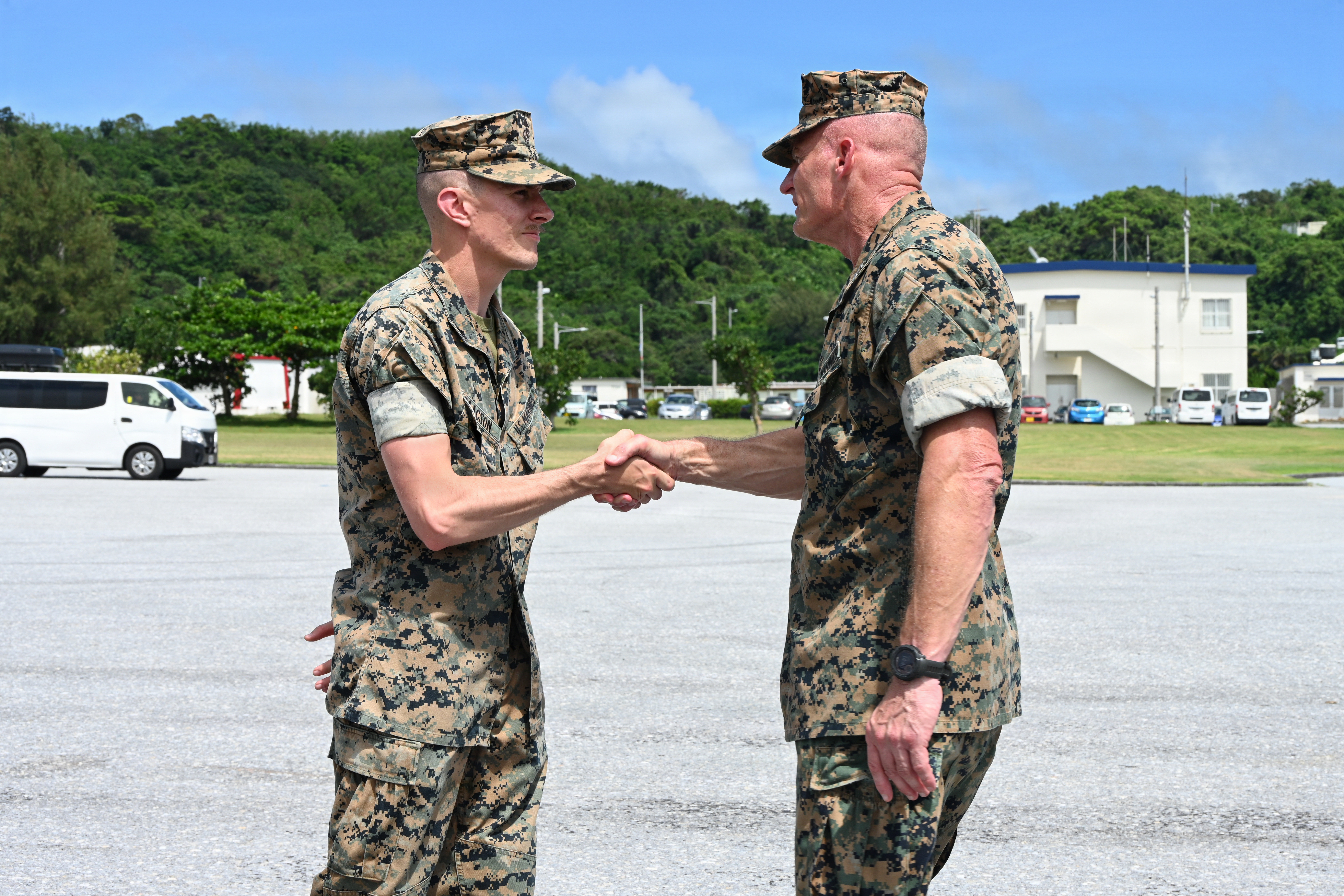 U.S. Marine Corps Lance Cpl. Blake Isaacson, left, a utilities systems technician with Intermediate Repair Company, 3rd Maintenance Battalion, 3rd Marine Logistics Group, receives a coin from Lt. Gen. Roger Turner, Commanding General of III Marine Expeditionary Force, during Valiant Shield 26 at White Beach, Okinawa, Japan, June 29, 2026. Intermediate Repair Company participated in Resilient Advanced Manufacturing for Contested Environments, or RAMFORCE, an initiative hosted by the Office of the Under Secretary of Defense for Research and Engineering. The innovative event brought together military personnel, government laboratories and private industry to evaluate how advanced manufacturing technologies could enable expeditionary forces to repair, replace and even produce critical equipment at the point of need. (U.S. Marine Corps photo by Cpl. Rachel Mason)