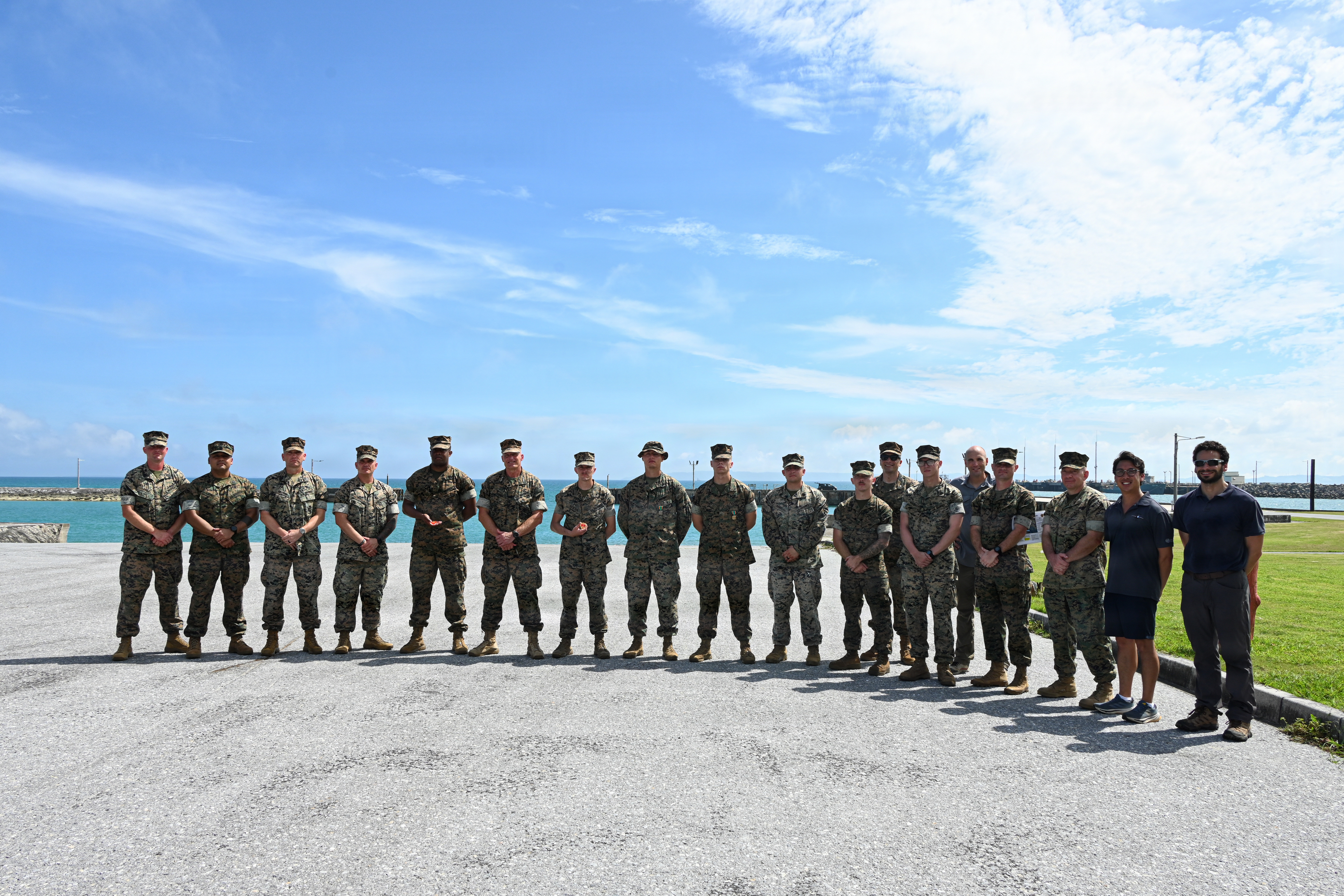 U.S. Marines and Department of Navy civilians from Naval Surface Warfare Center Carderock, pose for a group photo during Valiant Shield 26 at White Beach, Okinawa, Japan, June 29, 2026. Intermediate Repair Company participated in Resilient Advanced Manufacturing for Contested Environments, or RAMFORCE, an initiative hosted by the Office of the Under Secretary of Defense for Research and Engineering. The innovative event brought together military personnel, government laboratories and private industry to evaluate how advanced manufacturing technologies could enable expeditionary forces to repair, replace and even produce critical equipment at the point of need. (U.S. Marine Corps photo by Cpl. Rachel Mason)