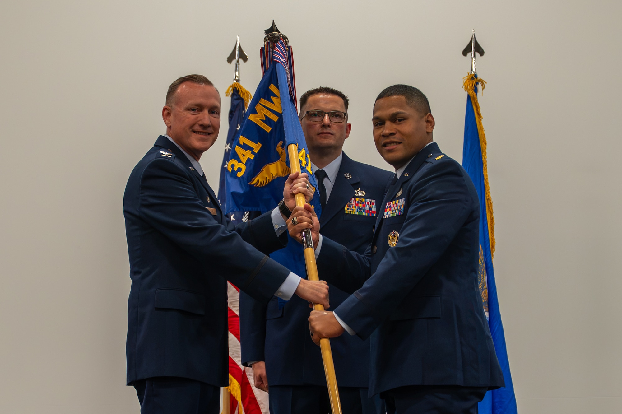 Uniformed personnel pose with a guidon for an assumption of command.